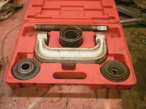 1995 Ford Bronco - A ball joint press tool kit is shown in its red plastic case, containing various metal components for automotive repair.