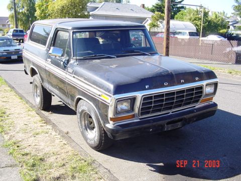 1979 Ford Bronco - A dark blue 1978 Ford Bronco is parked on the side of a street with other vehicles in the background.