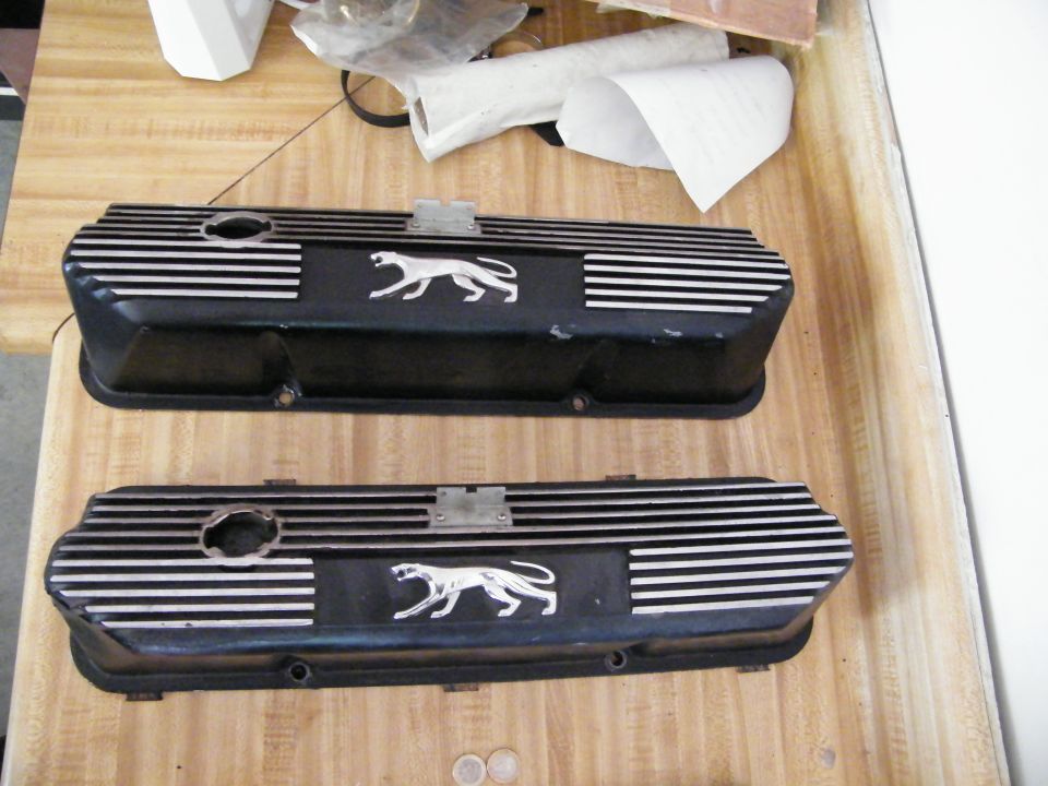 Two black engine valve covers with silver stripes and a cougar emblem
