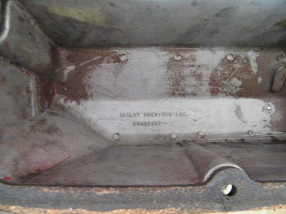 Metal part interior with stamped text 'SHELBY AMERICAN INC. 67A08582'