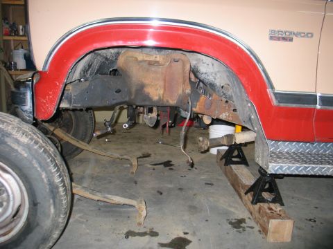 1984 Ford Bronco - The rear axle and suspension components of a 1984 Ford Bronco XLT are visible, with parts removed for maintenance.