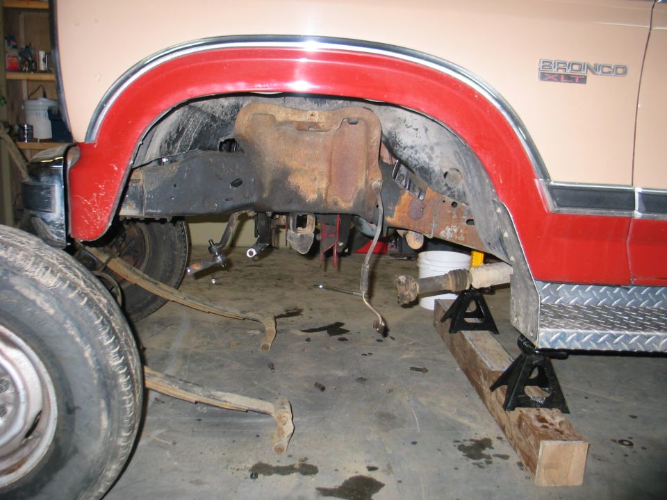 Rear suspension of a 1984 Ford Bronco XLT with leaf springs removed and vehicle on jack stands