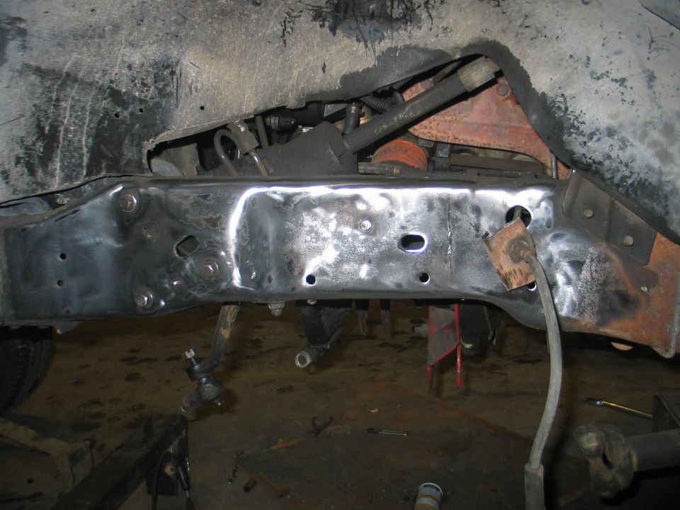 Vehicle frame with suspension parts, showing metalwork and rust