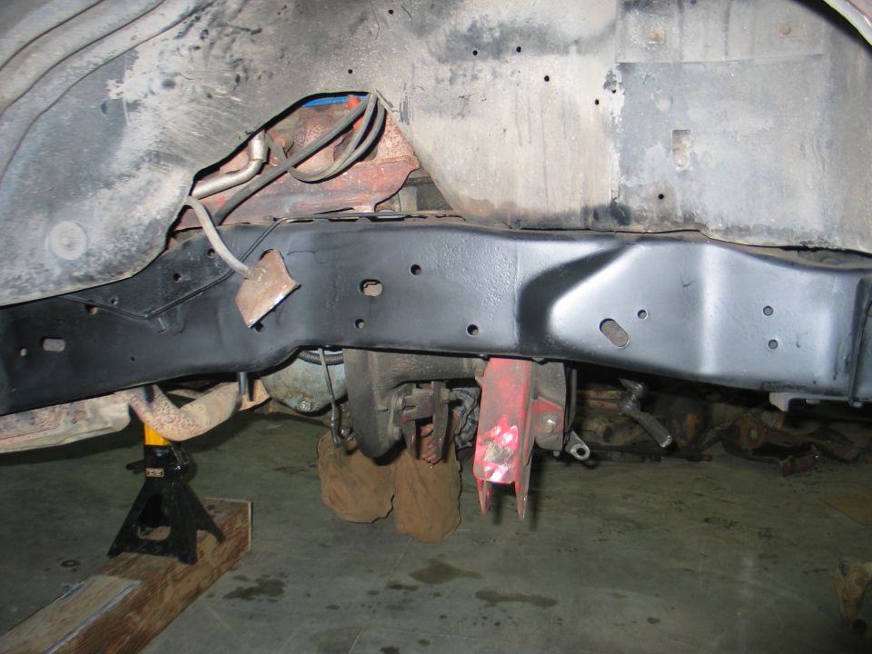 vehicle frame with suspension components and exhaust pipe supported by jack stands