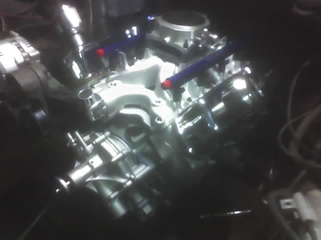 Engine intake with blue fuel rails and red injector caps, top-down view