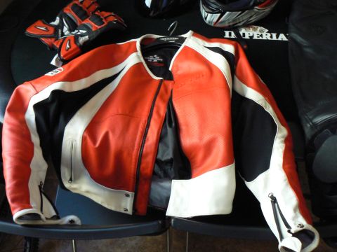 1978 Ford Bronco - Motorcycle racing jacket and gloves laid out with helmets in the background.