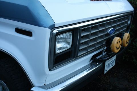 1989 Ford Bronco - This van features a prominent Ford grille and two smiley face fog lights mounted on the bumper.