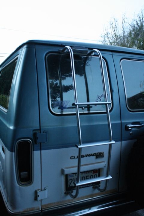 1989 Ford Bronco - Rear view of a van with a ladder mounted on the exterior.