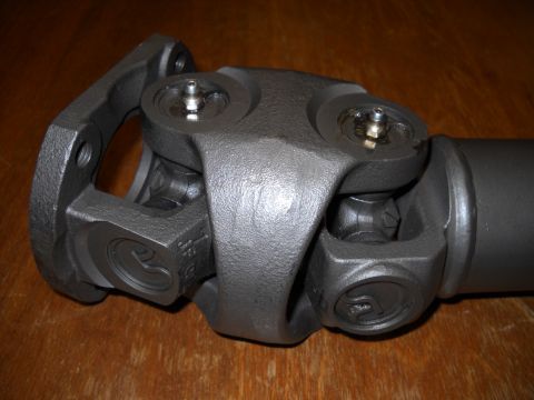 1991 Ford Bronco - A driveshaft U-joint assembly is shown resting on a wooden surface.