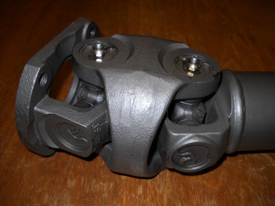 Gray-primered double-cardan driveshaft joint with new U-joints and grease fittings