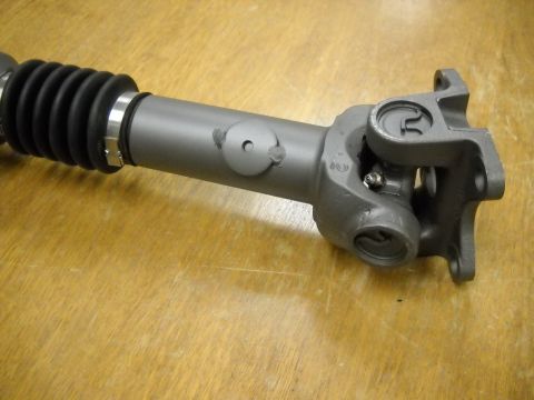1991 Ford Bronco - A close-up view of a driveshaft component, a U-joint and a protective rubber boot.