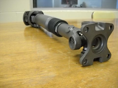 1991 Ford Bronco - A driveshaft is shown on a table, with a flange visible at one end.