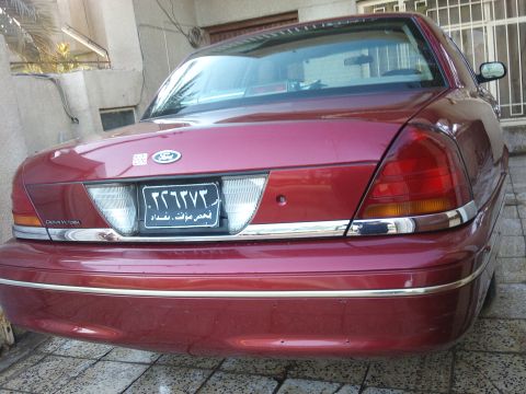 1998 Ford Crown Victoria - Rear view of a red 1998 Ford Crown Victoria with chrome accents and a license plate.