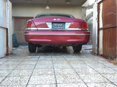 1998 Ford Crown Victoria - Rear view of a red 1998 Ford Crown Victoria parked in a garage.