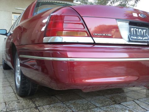 1998 Ford Crown Victoria - Rear view of a red 1998 Ford Crown Victoria showing the taillights and bumper detail.