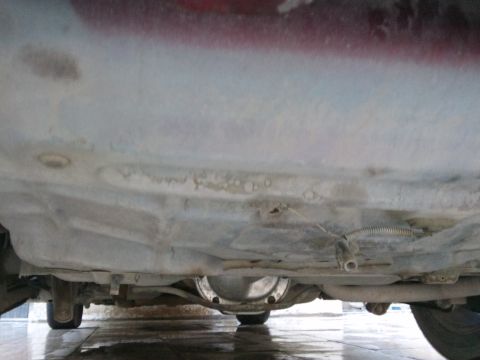 1998 Ford Crown Victoria - A low-angle shot reveals the undercarriage of a vehicle, including its drivetrain components.