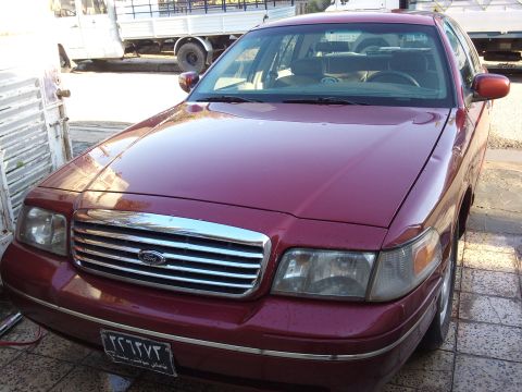 1998 Ford Crown Victoria - Front view of a maroon 1998 Ford Crown Victoria parked outdoors.