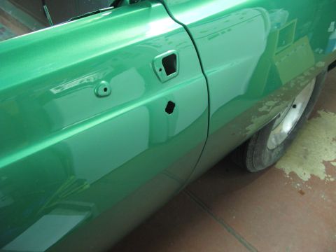 1971 Ford Ranchero - Side view of a 1971 Ford Ranchero with a green metallic paint job and the door handle removed.
