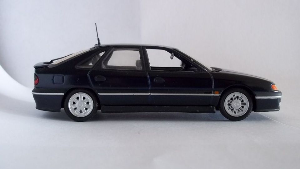 Side view of a dark blue scale-model hatchback with silver wheels on white background