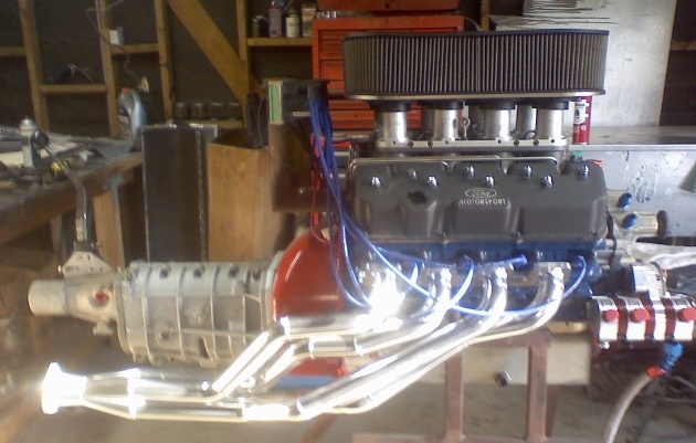 Ford Motorsport V8 engine with headers and transmission on bench