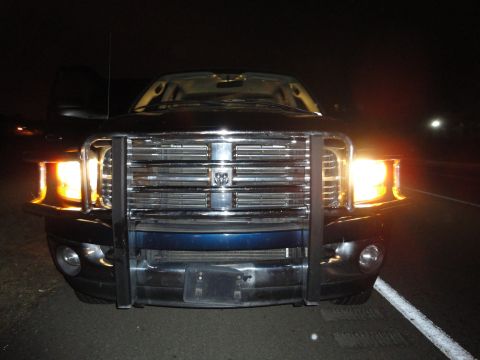2006 Dodge 2500 - Front view of a 2006 Dodge 2500 pickup truck at night, equipped with a chrome bull bar.
