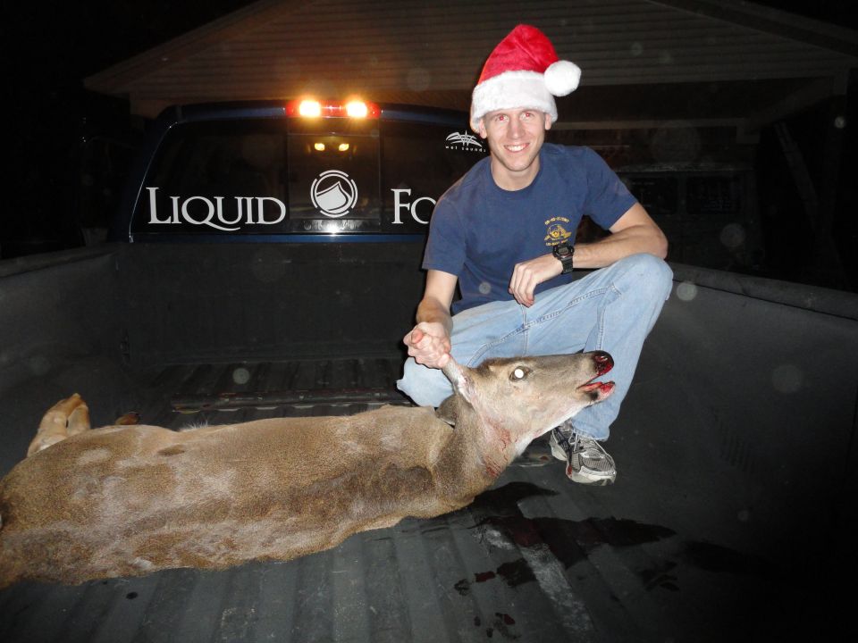 Blue pickup truck bed with a deer and a man in a Santa hat