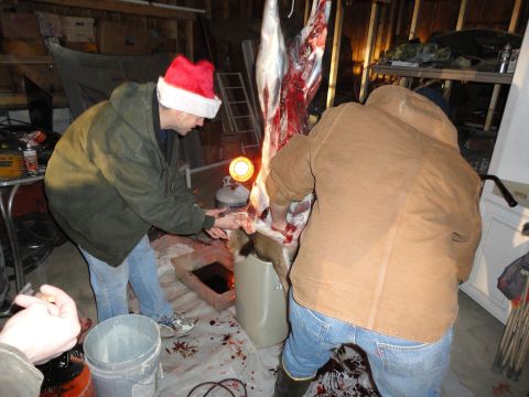 2006 Dodge 2500 - Butchering a deer in a garage, one person wears a Santa hat.