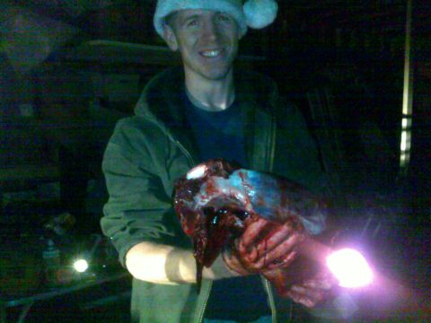 2006 Dodge 2500 - A man in a Santa hat holds a bloody animal carcass, with the Supermotors.net logo in the corner.