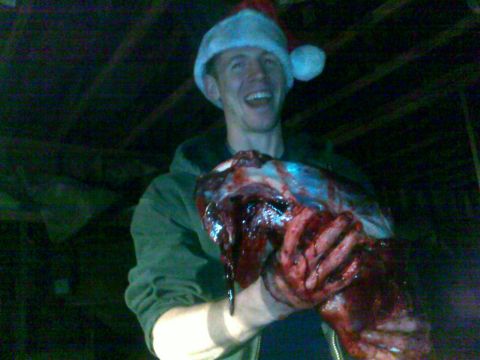2006 Dodge 2500 - Man in Santa hat holds bloody animal carcass. Supermotors.net logo visible.