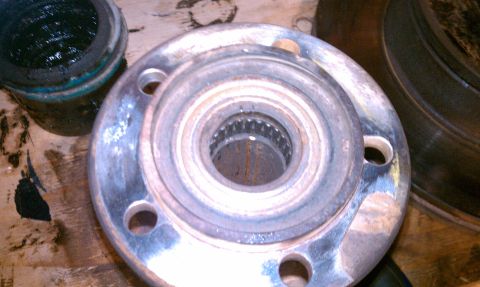 1994 Ford F-150 - A wheel hub assembly is shown with a separate container of grease and a brake rotor in the background.