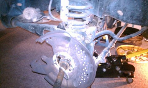 1994 Ford F-150 - Rear suspension components of a truck, including brake rotor and coil spring, are visible.