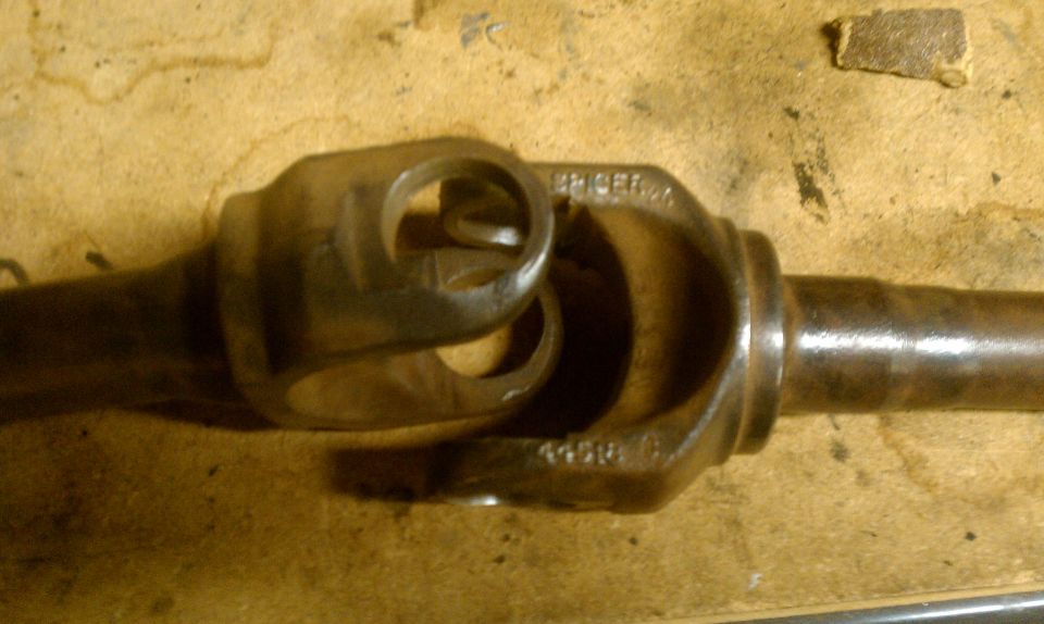 Close-up of a driveshaft U-joint with part numbers visible