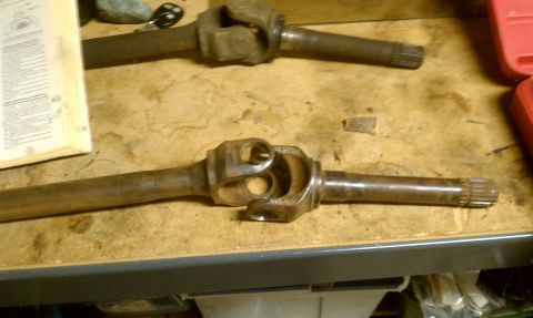 1994 Ford F-150 - Two driveshafts are laid out on a workbench, possibly for repair or replacement.