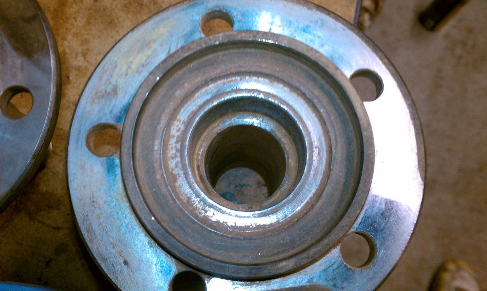 Wheel hub assembly with four bolt holes and a central opening, showing wear and rust