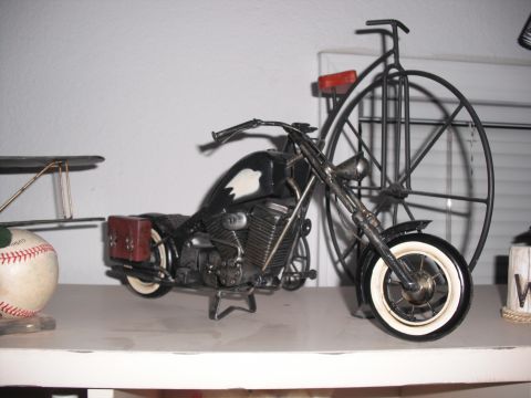 1991 Ford Bronco - A decorative metal model of a motorcycle is displayed on a shelf, with a large spoked wheel behind it.