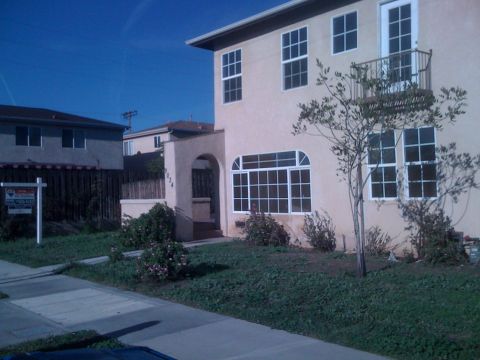 1968 Ford Mustang - A two-story house with a stucco exterior and a prominent arched window is shown with a balcony and a 'For Sale' sign in the front yard.