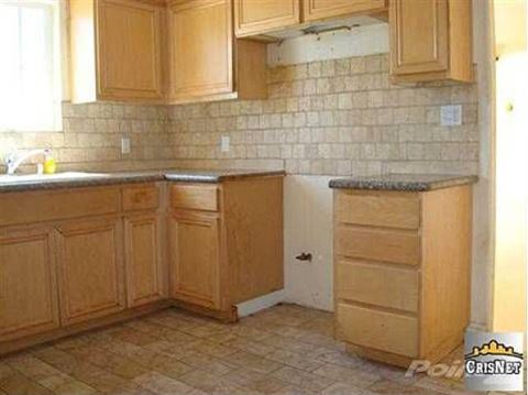 1968 Ford Mustang - A kitchen interior with wooden cabinets, a sink, and a tiled backsplash.