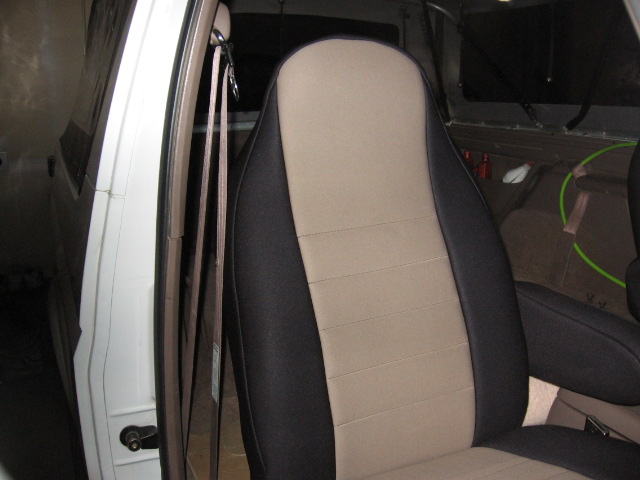 Front bucket seat with tan and black seat cover in an SUV interior