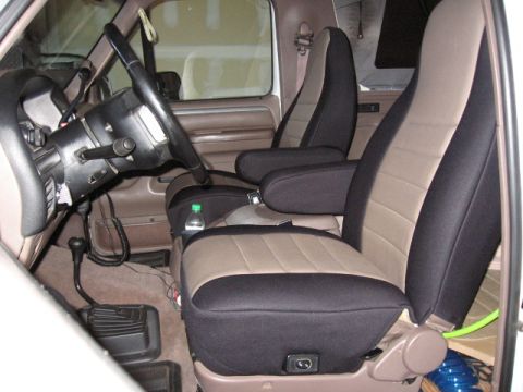 1995 Ford Bronco - Two-tone seat covers in black and tan are installed on the bucket seats and armrests of this vehicle's interior.