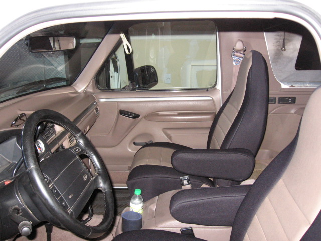Truck interior with black steering wheel, tan dash and two-tone black/tan seats