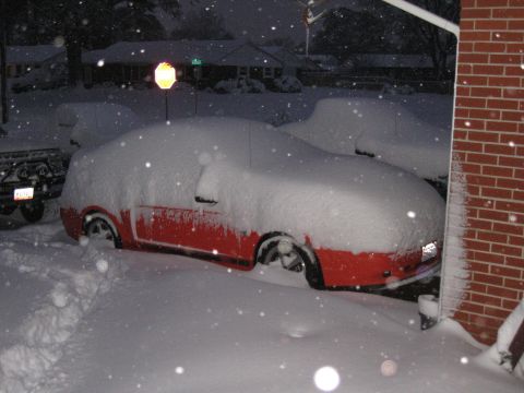 1994 Ford Bronco - Two cars are buried under a thick blanket of snow on a winter night.
