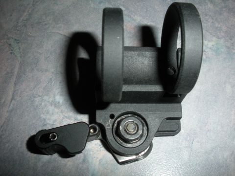 1996 Ford Bronco - Close-up of a black scope mount two rings and an adjustable lever mechanism, with "SUPERMOTORS" text visible at the bottom right.