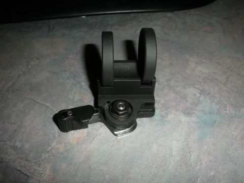 1996 Ford Bronco - A close-up view of a black flip-up firearm sight with a lever mechanism.