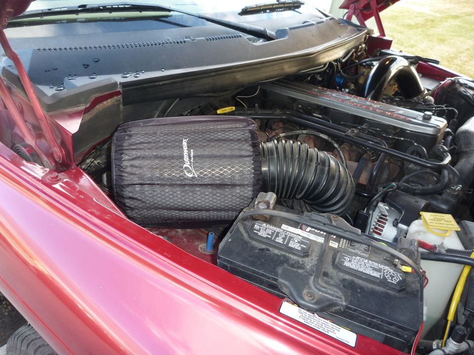 Red 1997 Dodge 2500 engine bay with aftermarket air filter and battery