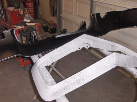 1972 Chevrolet Camaro - Two car bumper sections are shown in a garage, one black and one primed white, resting on sawhorses.