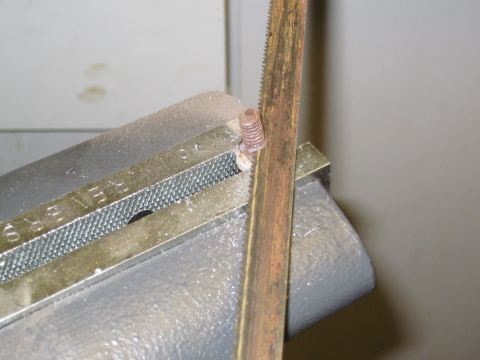 1979 Ford Bronco - A hacksaw blade cuts through a bolt secured in a vise, with visible text on the vise reading 'REVERS'.