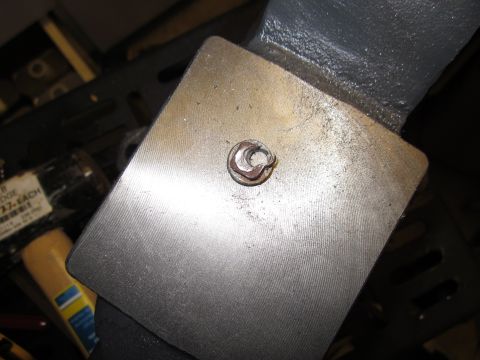 1979 Ford Bronco - Metal plate with a nut and washer, part of some assembly or repair.