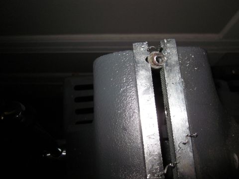 1979 Ford Bronco - A metal bracket holds a cable in place, with some text visible on the bracket.