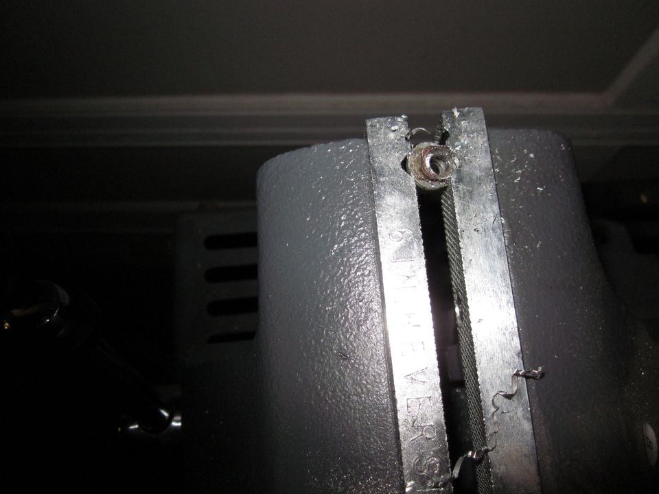 Close-up of a cable secured by a metal bracket with a bolt