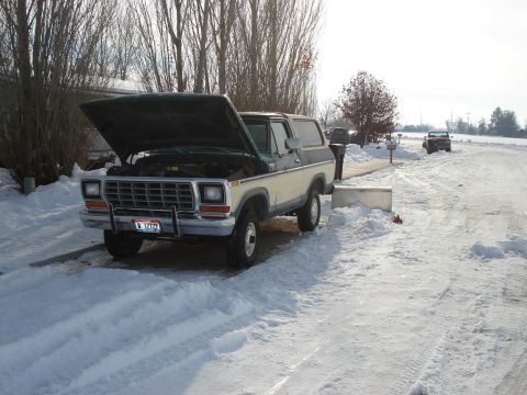 1979 Ford Bronco - 1978 Ford Bronco parked in the snow with its hood up. A second vehicle is in the distance.